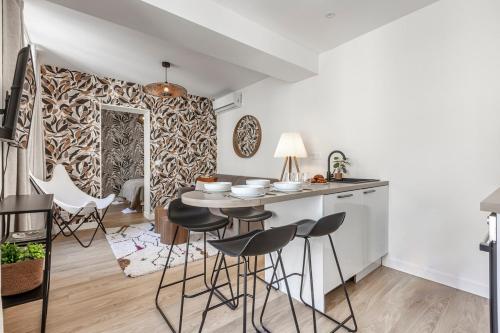 une cuisine avec une table et des tabourets dans une pièce dans l'établissement B31#République#Marais#1BedRoom#Paris03#Air conditioning, à Paris