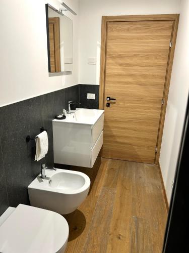 a bathroom with a toilet and a sink and a door at Cimus Home in SantʼAntonio Tortal