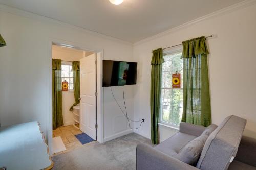 a living room with a couch and a tv at 2 Mi to South Boston Speedway Cozy Tiny Home! in South Boston