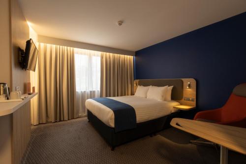 a hotel room with a bed and a window at Holiday Inn Express Poole by IHG in Poole