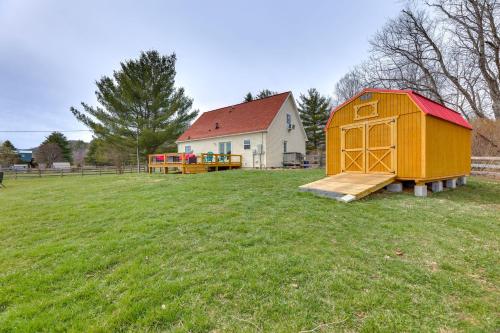 a play structure in a field next to a house at McDowell Highland County River Retreat with Views! in Williamsville