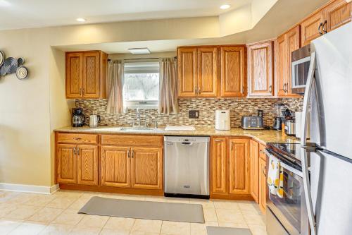 a kitchen with wooden cabinets and stainless steel appliances at 3 Mi to Berkshire Mall Suburban Stay with Yard! in Sinking Spring