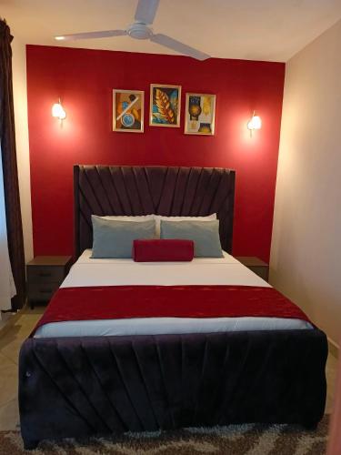 ウクンダにあるCatwalk Factory Apartmentの赤い壁のベッドのある寝室