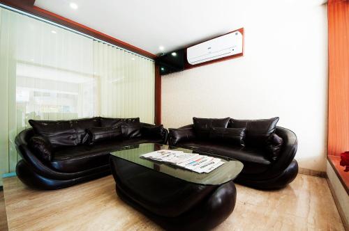 a living room with two leather couches and a table at Uddhav Vilas A Family Hotel in Udaipur