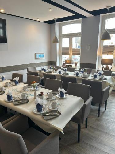a dining room with tables and chairs with dishes on them at Hotel & Restaurant Christian IV in Glückstadt