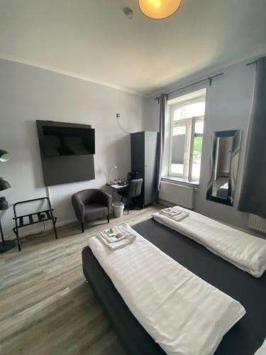 a hotel room with two beds and a tv at Hotel & Restaurant Christian IV in Glückstadt