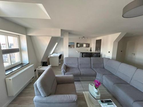 a living room with a sectional couch and a living room with at Hotel & Restaurant Christian IV in Glückstadt