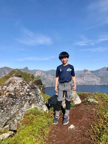 a young boy standing on top of a mountain at Linda`s house in Grashopen