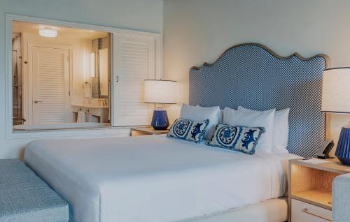 a bedroom with a large white bed with blue pillows at The Seagate in Delray Beach