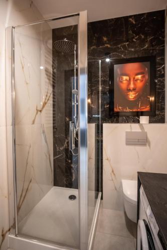 a bathroom with a shower with a television on the wall at Azymut 48C in Stary Folwark