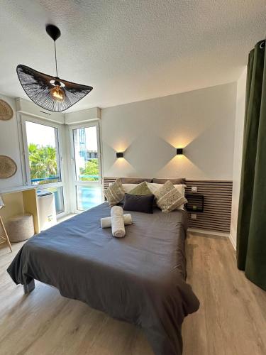 une chambre avec un grand lit avec deux serviettes dessus dans l'établissement Studio MBS 1 - Cosy, Tram, Wifi, Parking, Equipé, à Montpellier