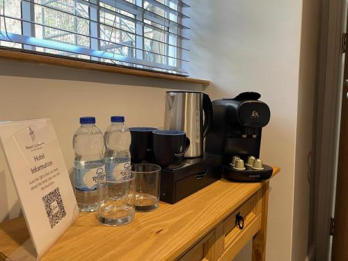 a counter with a coffee maker and water bottles on it at Prince Llewelyn Hotel in Beddgelert