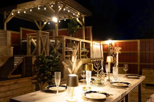 a table with plates and glasses and lights on it at Prästkragen in Ullared