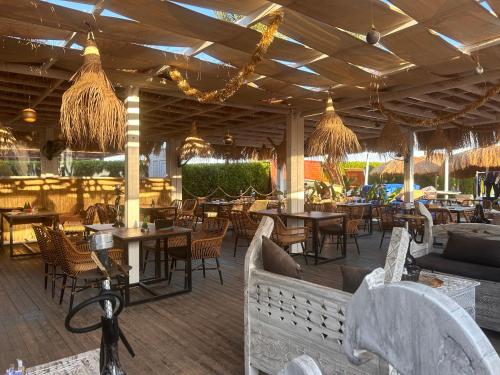 Un restaurante con mesas, sillas y lámparas de araña. en Cosy Studio on the First Floor with lovely Terrace and Personal Garden Area, Pool View and Free Beach Access in Sharm Hills Resort, en Sharm El Sheikh
