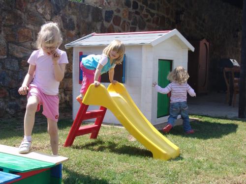 two little girls playing on a slide in the yard at Penzion V polích in Malé Číčovice
