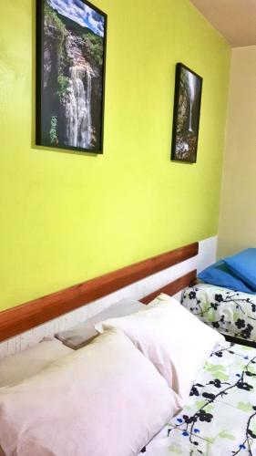 a bedroom with two beds and a yellow wall at Pousada Recanto da Chapada in Mucugê