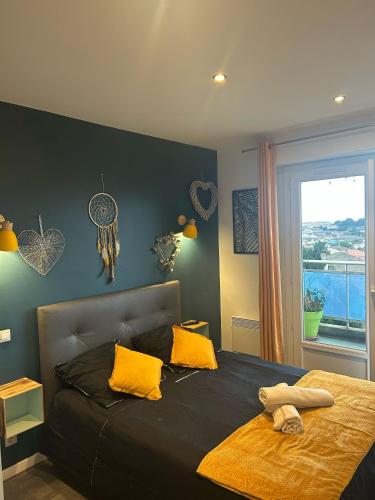 une chambre avec un lit avec des oreillers jaunes et une fenêtre dans l'établissement Le rêve bleu Grand Balcon, à Carcassonne