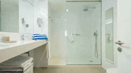 a white bathroom with a shower and a sink at El Yate in San Agustin