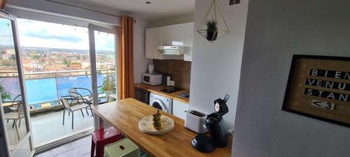 - une cuisine avec une table et une vue sur la ville dans l'établissement Le rêve bleu Grand Balcon, à Carcassonne