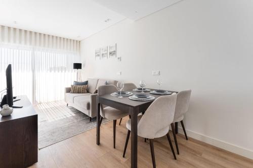 a living room with a table and chairs and a couch at GuestReady - Ideal stay near Estádio do Dragão in Porto