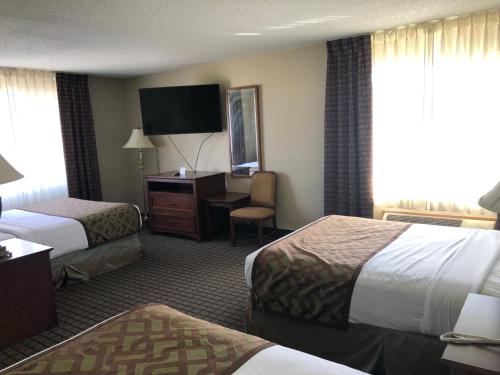 a hotel room with two beds and a desk at Regency Inn Geneseo IL I-80 in Geneseo
