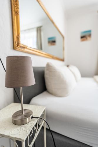 a lamp on a table next to a white couch at Villa Backstein OBO19 in Schwerin