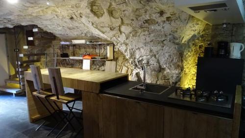 a kitchen with a counter and a stone wall at AgriIlGeco I - L Angolo di Papà Gigi - by HOST4U in Civezza