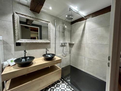 a bathroom with two sinks and a shower at Château de la Rive - Suite des Coteaux - Duplex 6 personnes in Cruet