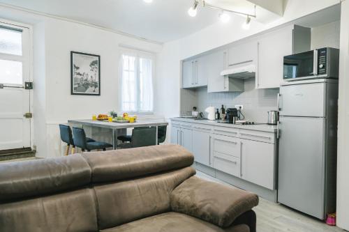 un salon avec un canapé et une cuisine dans l'établissement Au pied des remparts- Maison de caractère-3 Ch-AC, à Carcassonne