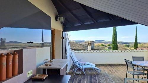 a patio with chairs and a table and a large window at Maison Louisa in Manas