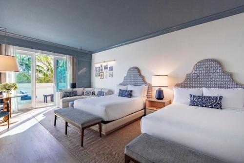 a bedroom with two beds and a living room at The Seagate in Delray Beach