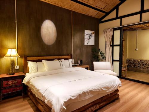 a bedroom with a large white bed and a chair at Dalin Xiaoyuan Shiqi Store in Lijiang