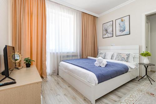 a bedroom with a bed and a television in it at Мангилик жилой комплекс in Astana