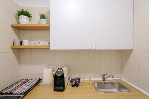 a kitchen counter with a sink and a counter top with a appliance at CasaLù in Bari