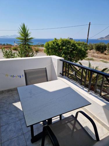 a table and chair on a balcony with the ocean at Sea View Luxury Studios in Vrachonisída Palaiókastro
