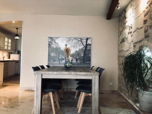 une table de salle à manger avec des chaises et un tableau au mur dans l'établissement Appartement quartier roquette Arles, à Arles