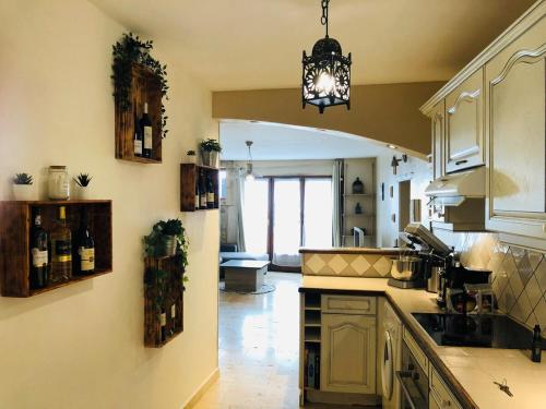 une cuisine avec des armoires blanches et un lustre dans l'établissement Appartement quartier roquette Arles, à Arles