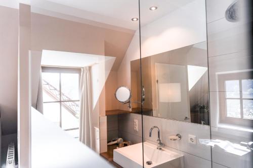 een badkamer met een wastafel en een spiegel bij Donauwirt - Hotel garni in Weissenkirchen in der Wachau
