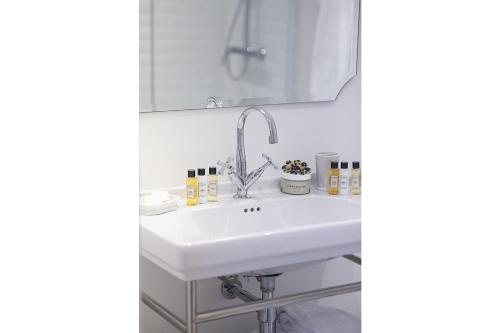 a white sink in a bathroom with a mirror at Villa Aitama in Cap-Ferret