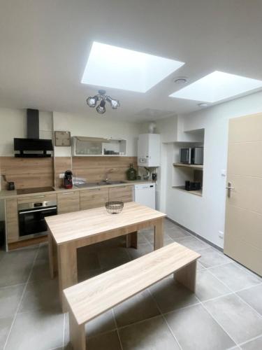 - une cuisine avec une table et un banc dans l'établissement L'écrin de Paray, sleeps 6, à Paray-le-Monial