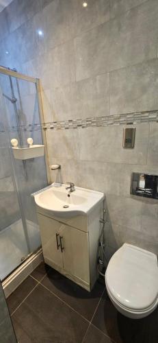 a bathroom with a white sink and a toilet at Mitcham Eastfields Studio in Streatham Vale