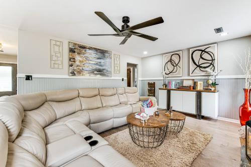 a living room with a white couch and a ceiling fan at 4 Mi to Airport Atlanta Home with Deck and Hot Tub in Forest Park