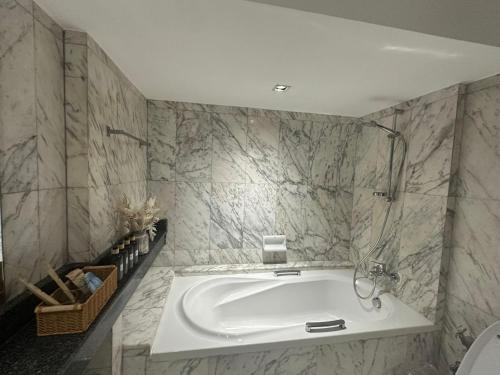 a large white tub in a bathroom with marble walls at 5BR Villa with Private Pool Sukhumvit 10mins BTS in Bangkok