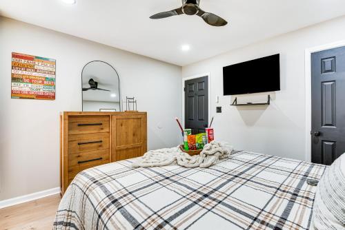 a bedroom with a bed and a flat screen tv at 4 Mi to Airport Atlanta Home with Deck and Hot Tub in Forest Park