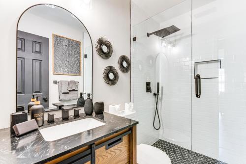 a bathroom with a sink and a shower with a mirror at 4 Mi to Airport Atlanta Home with Deck and Hot Tub in Forest Park