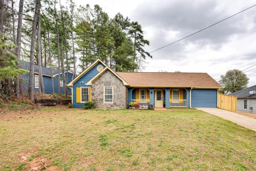 a home with a blue house and a yard at 4 Mi to Airport Atlanta Home with Deck and Hot Tub in Forest Park