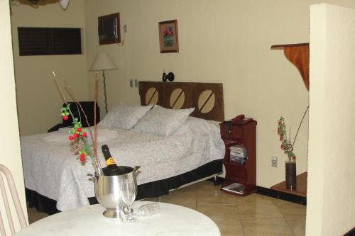 a bedroom with a bed and a table at Café Palace Hotel in Três Pontas