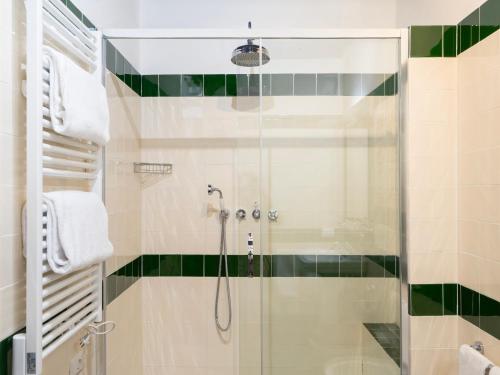 a bathroom with a shower with green and white tiles at Borgia di Firenze in Florence