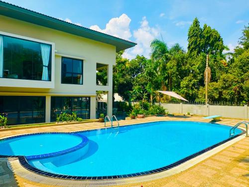 a swimming pool in front of a house at 5BR Villa with Private Pool Sukhumvit 10mins BTS in Bangkok
