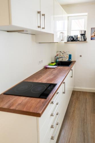 a kitchen with white cabinets and a wooden counter top at Villa Backstein OBO19 in Schwerin